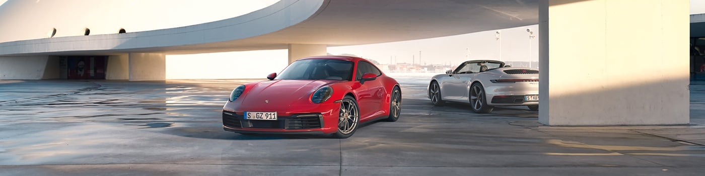 Porsche 911 Models Red and White 911 models parked underneath a modern building
