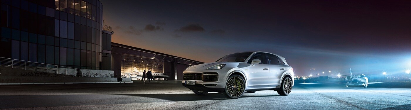 White Cayenne E-Hybrid parked at an airport