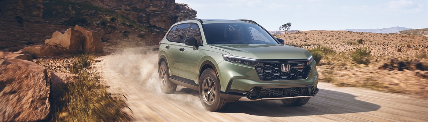 Green Honda CR-V Hybrid TrailSport driving in the desert