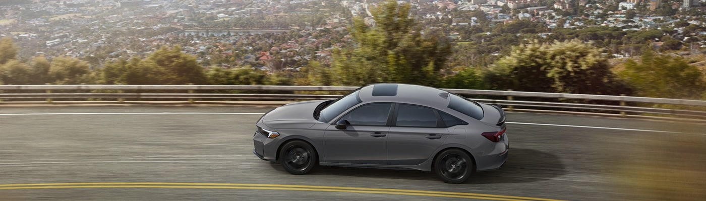 Honda Civic Si Grey Honda Civic Si driving on a highway about the city