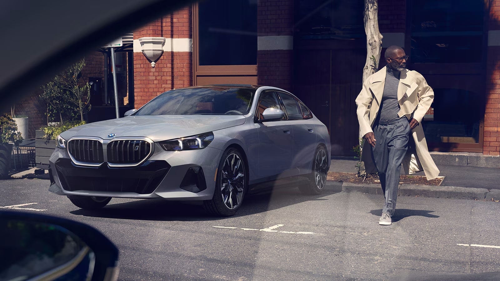 red 2024 BMW i5 parked in city setting