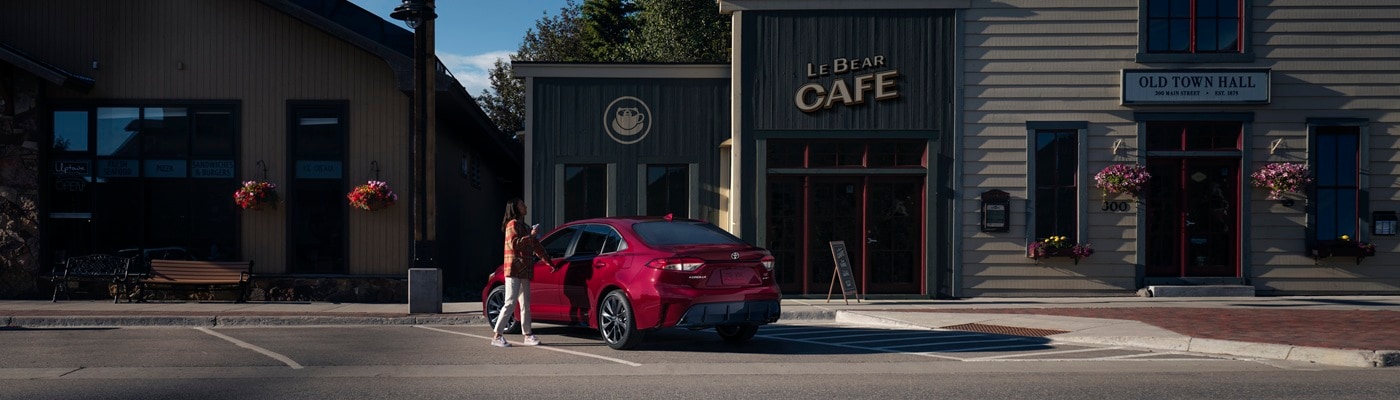 Red Toyota Corolla Hybrid SE parked on a street in a mountain town