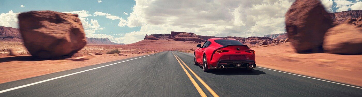 Red Toyota GR Supra Final Edition driving on a road in the desert