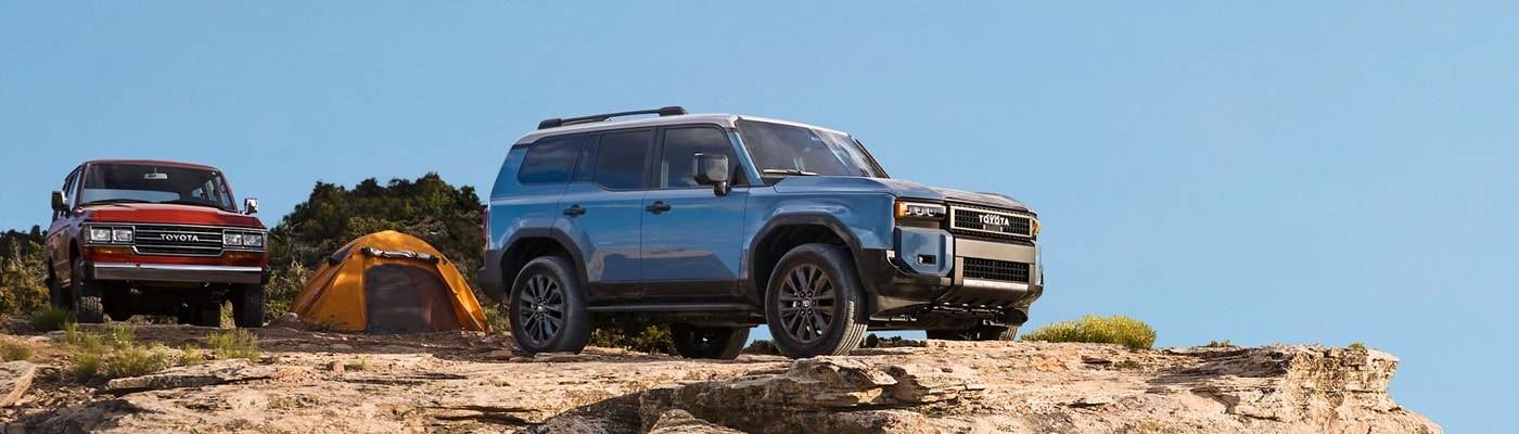 Blue Toyota Land Cruiser parked at the edge of a cliffside camp site