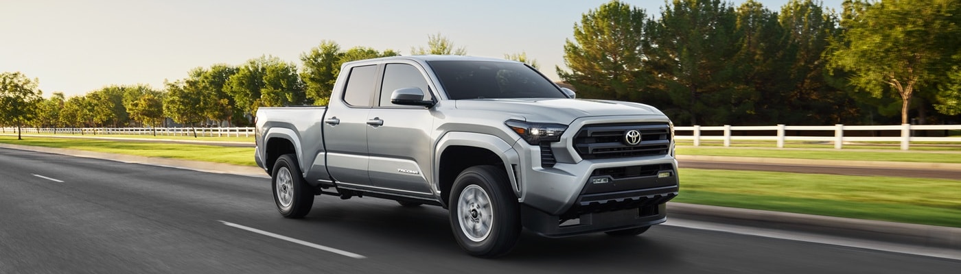 Silver Toyota Tacoma SR5 driving on a grassy road in the suburbs