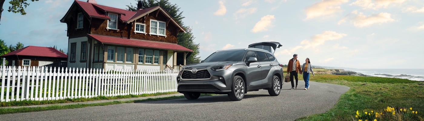 Gray Toyota Highlander Hybrid Limited parked by a seaside house