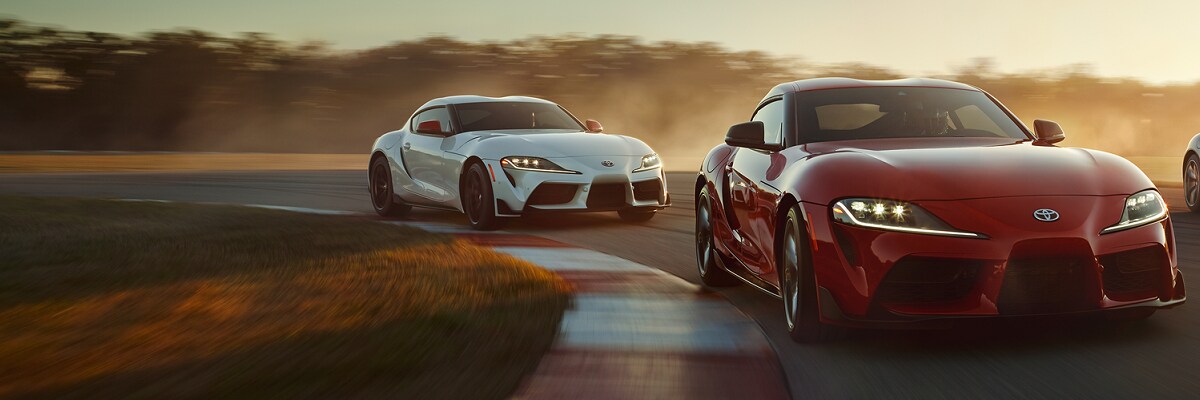 two Toyota GR Supra cars driving on a track