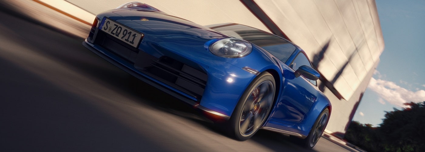 Blue 911 Carrera driving on a city street