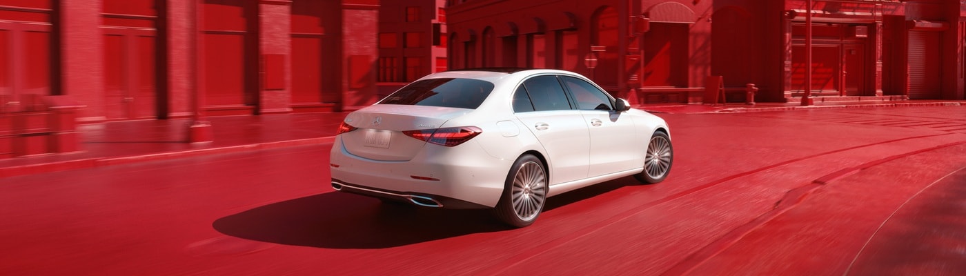 Mercedes-Benz AMG C-Class White Mercedes-Benz AMG C 43 sedan driving in a red cityscape