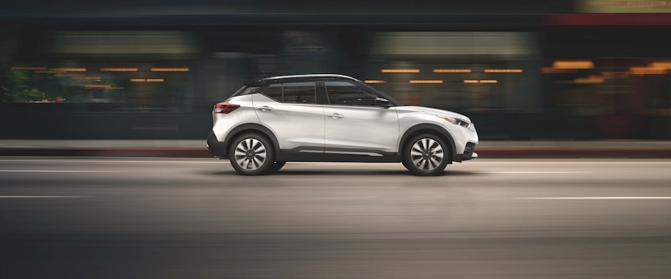 White Nissan Kicks A white Nissan Kicks driving down the city street