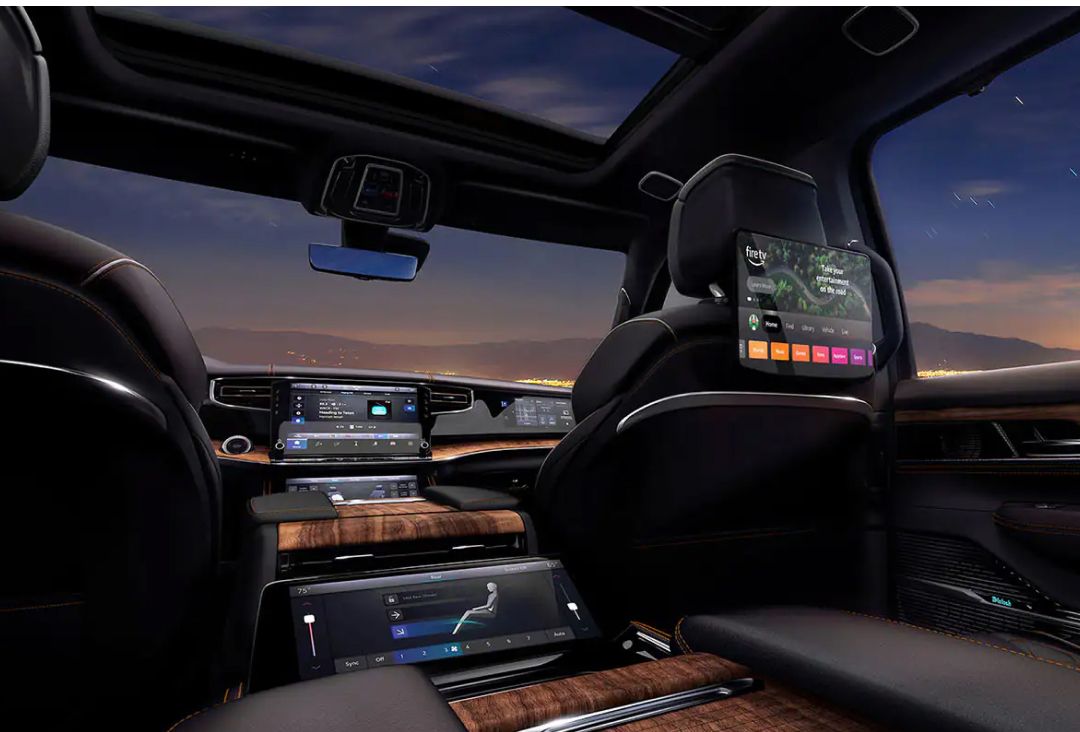 Jeep Grand Wagoneer interior featuring multiple digital displays, premium seating, and a panoramic roof.
