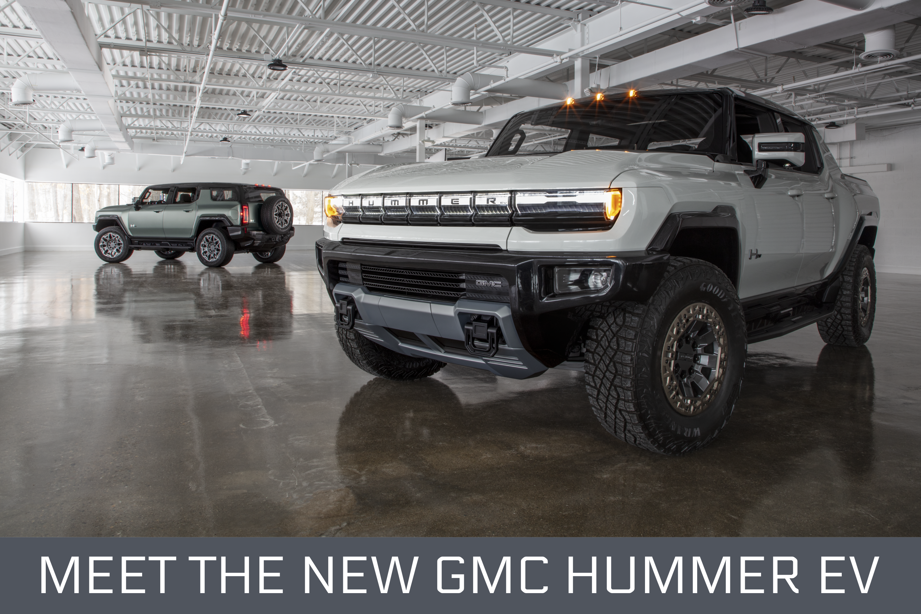 New Hummer EV truck and SUV in garage with words “Meet the New GMC Hummer EV” below