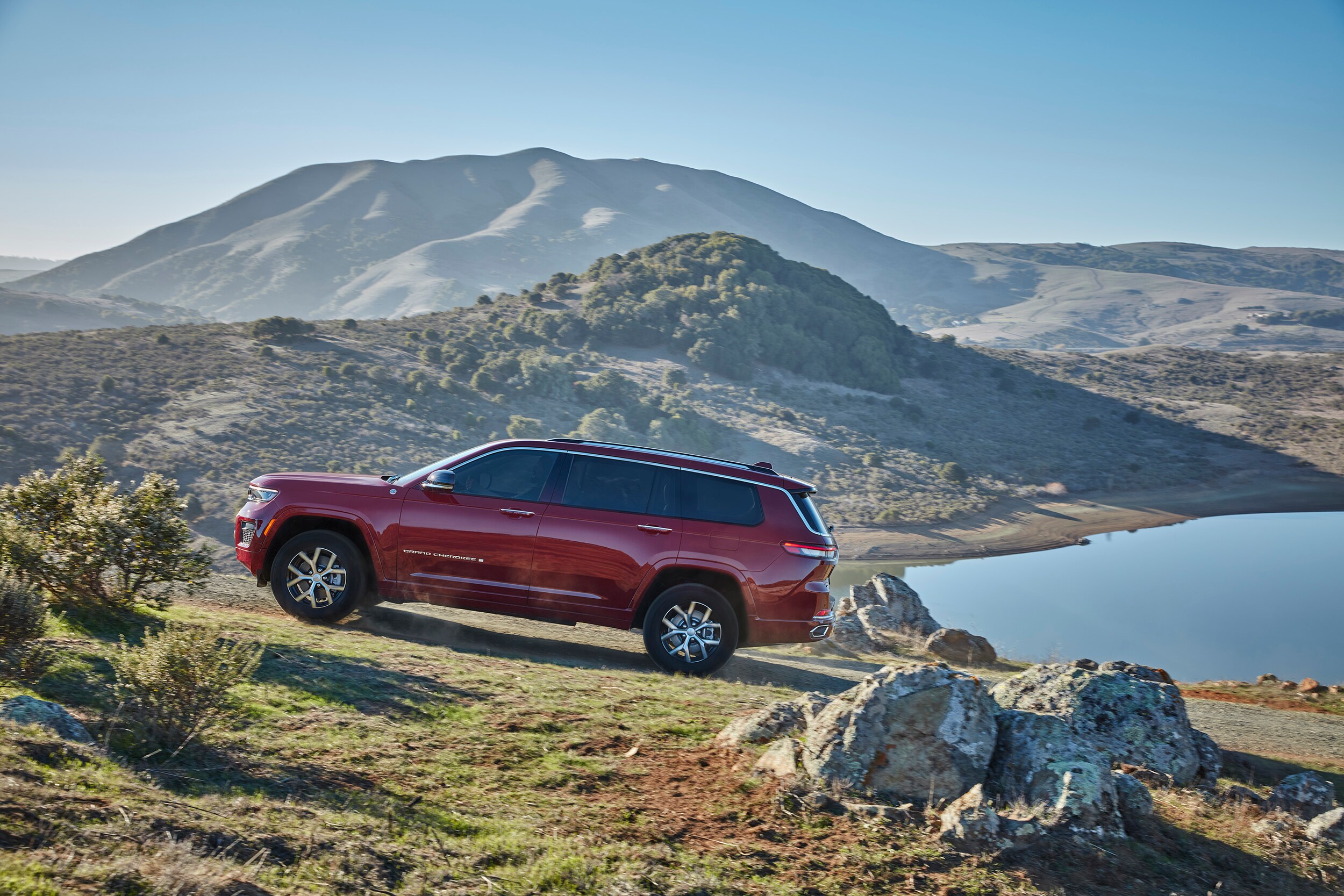 Side View of red Grand Cherokee L going up hillside