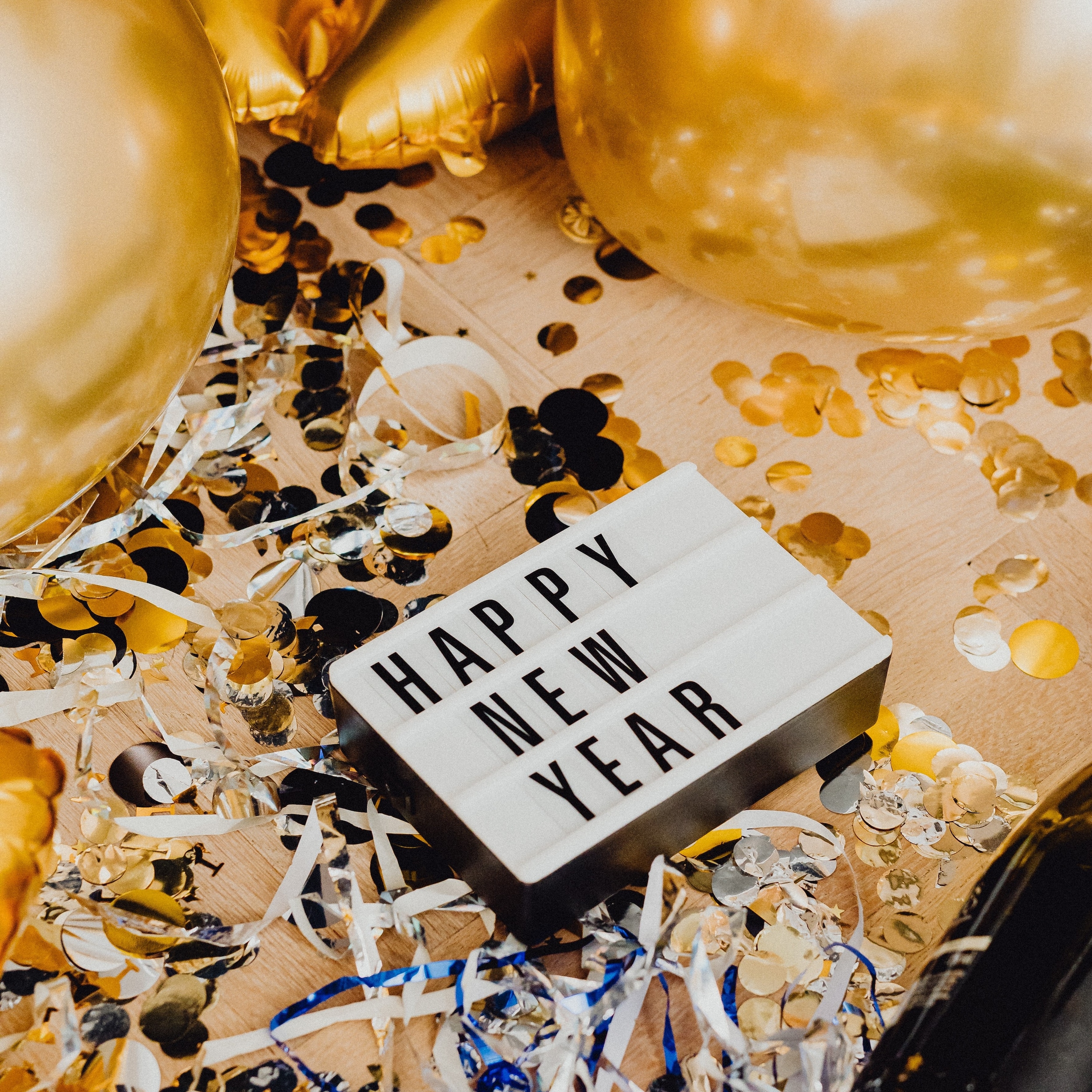 Happy New Year Sign with Gold balloons and confetti