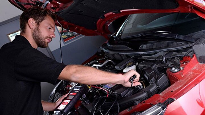 Person Working Under the Hood of Vehicle