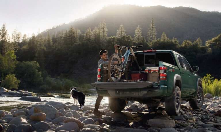 2024 Nissan Frontier Exterior With Driver Getting Bike From Bed