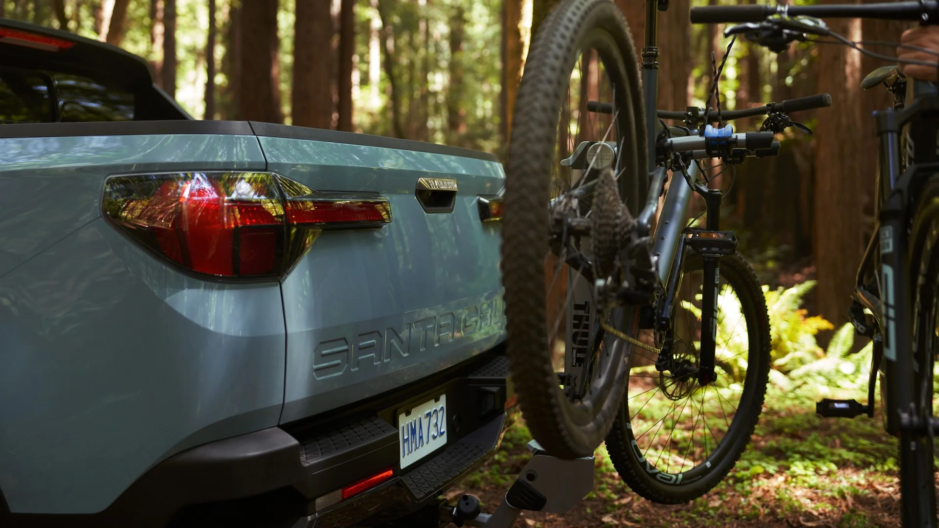 Open tailgate of a Hyundai Santa Cruz with a mountain bike loaded in the bed, at Sport Durst Hyundai in Durham, NC