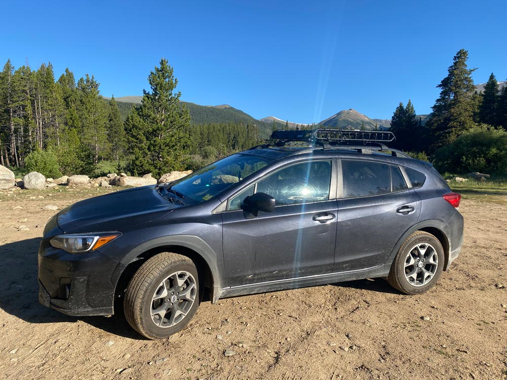 Crosstrek at an overlook with mountain vista behind