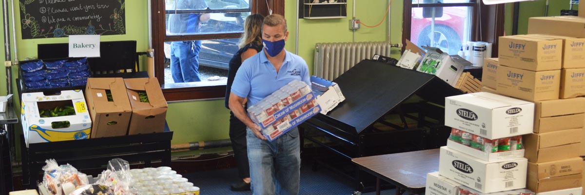 Mark Politte (masked), helping store boxes of food at Bar Harbor Food Pantry