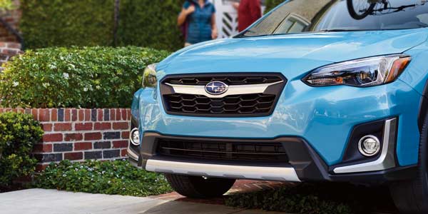 Crosstrek parked in a drive with short hedges