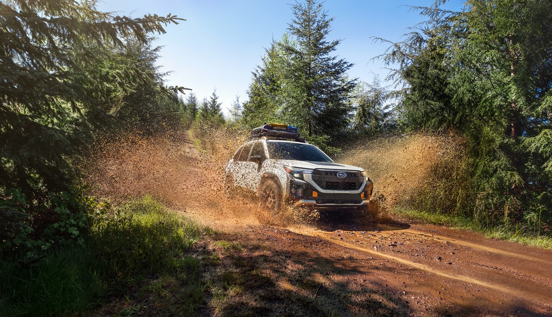  2026 Subaru Forester driving on muddy dirt road