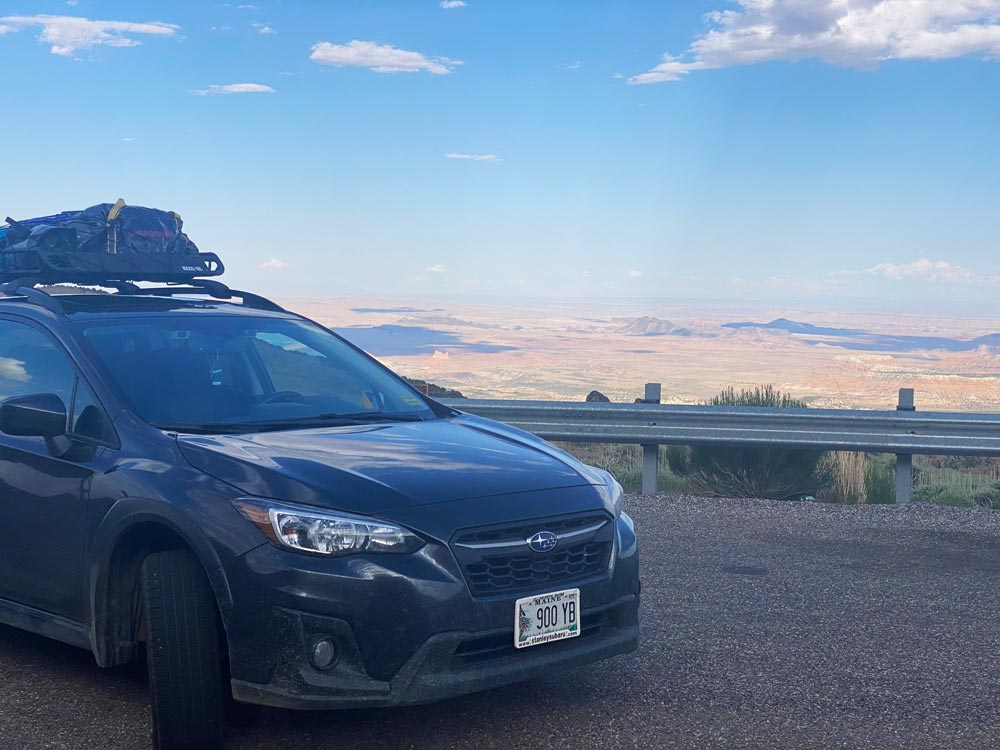 Crosstrek on an overlook with a massive desert behind