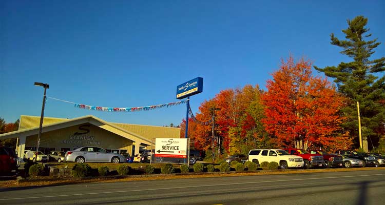 View of the annex with a service sign on display and bright orange and red trees in the background