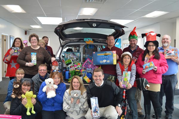 Geddy with the Stanley team holding toys donated to the local toy drive