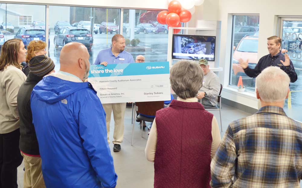John holds the giant check while Mark gives a short speech