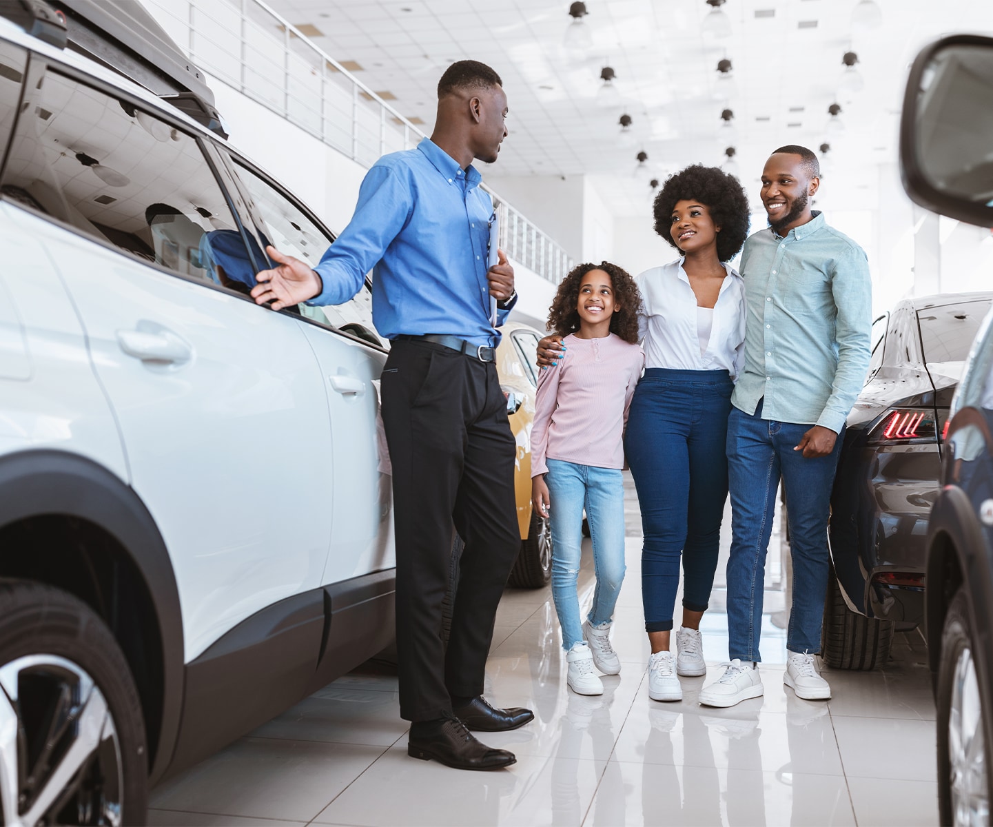 Volvo Dealer in Greensburg | Sales person showing a family the car options in the dealership 
