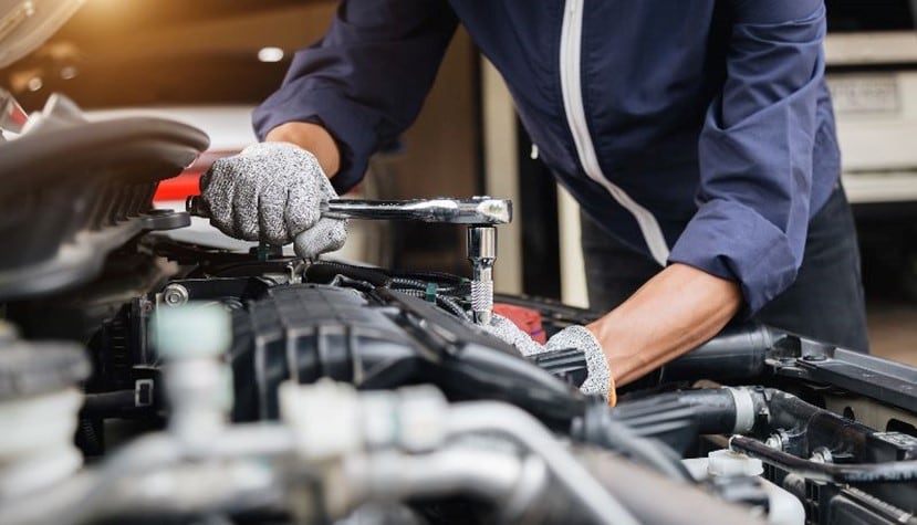 Auto mechanic working on a car engine