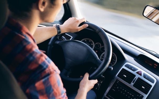 man holding steering wheel