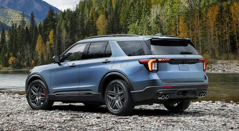 A blue 2025 Ford Explorer ST parked near a riverbed.
