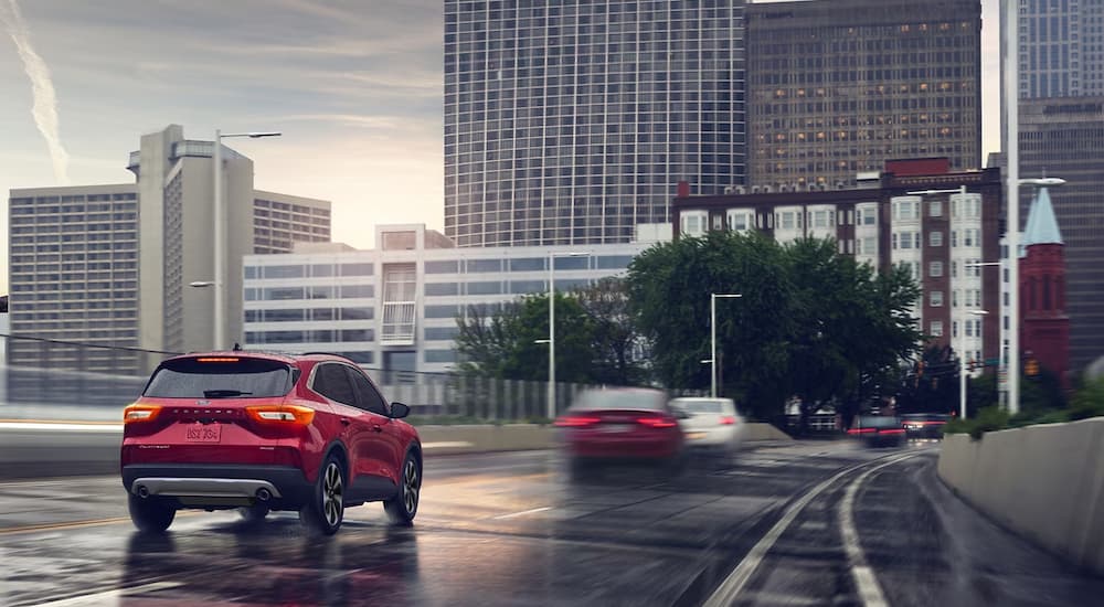 A red 2024 Ford Escape Platinum driving on a highway.