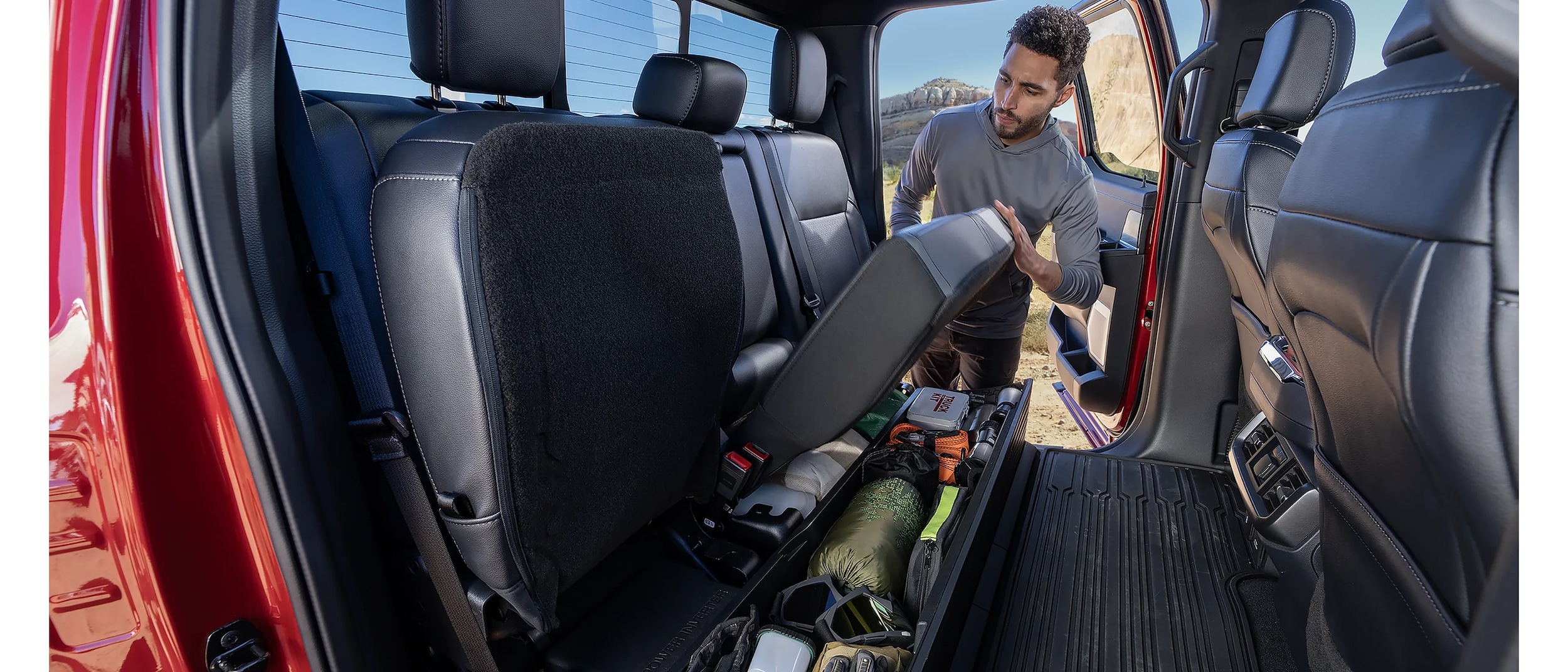 2025 Ford F-150® Raptor R® pickup in Carbonized Gray kicking up a cloud of dust in the desert