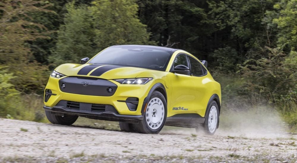 Ford%20Mustang%20Mach-E%20for%20Sale%20-%202024%20Ford%20Mustang%20Mach-E%20Rally%20Edition%20-%20Trail%202.jpg A yellow 2024 Ford Mustang Mach-E Rally Edition driving down a trail.