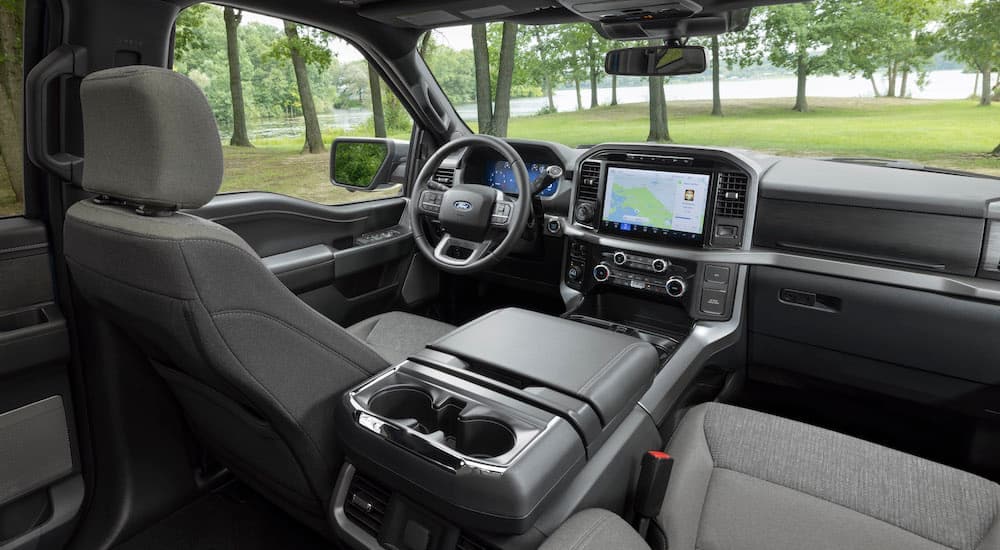 The grey interior of a 2024 Ford F-150 XLT is shown from the back seats.
