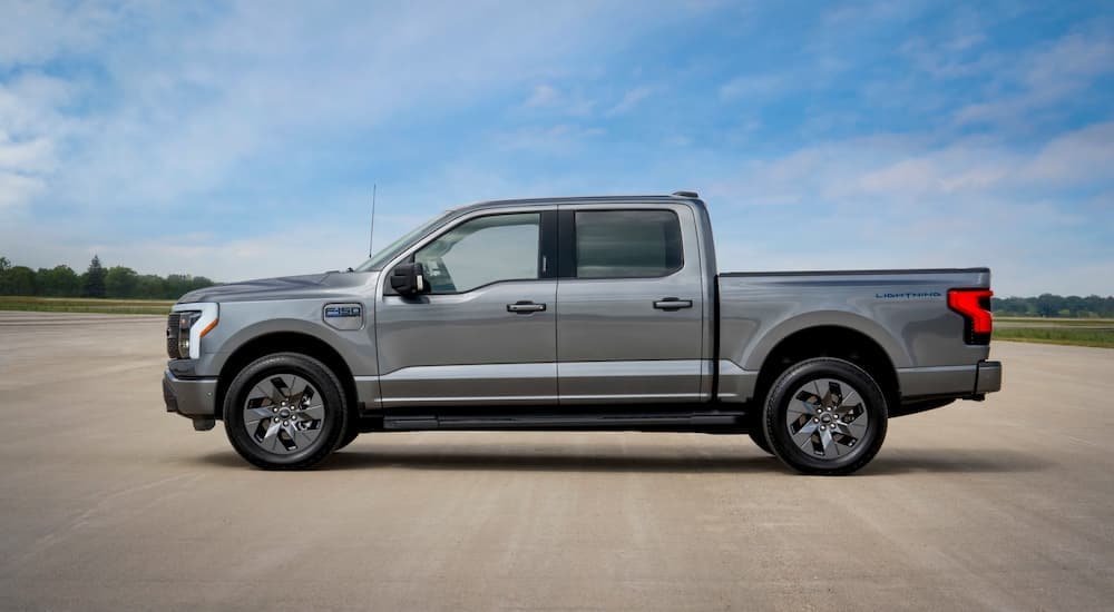 A grey 2024 Ford F-150 Lightning Flash for sale near Jackson is parked at a dealership.