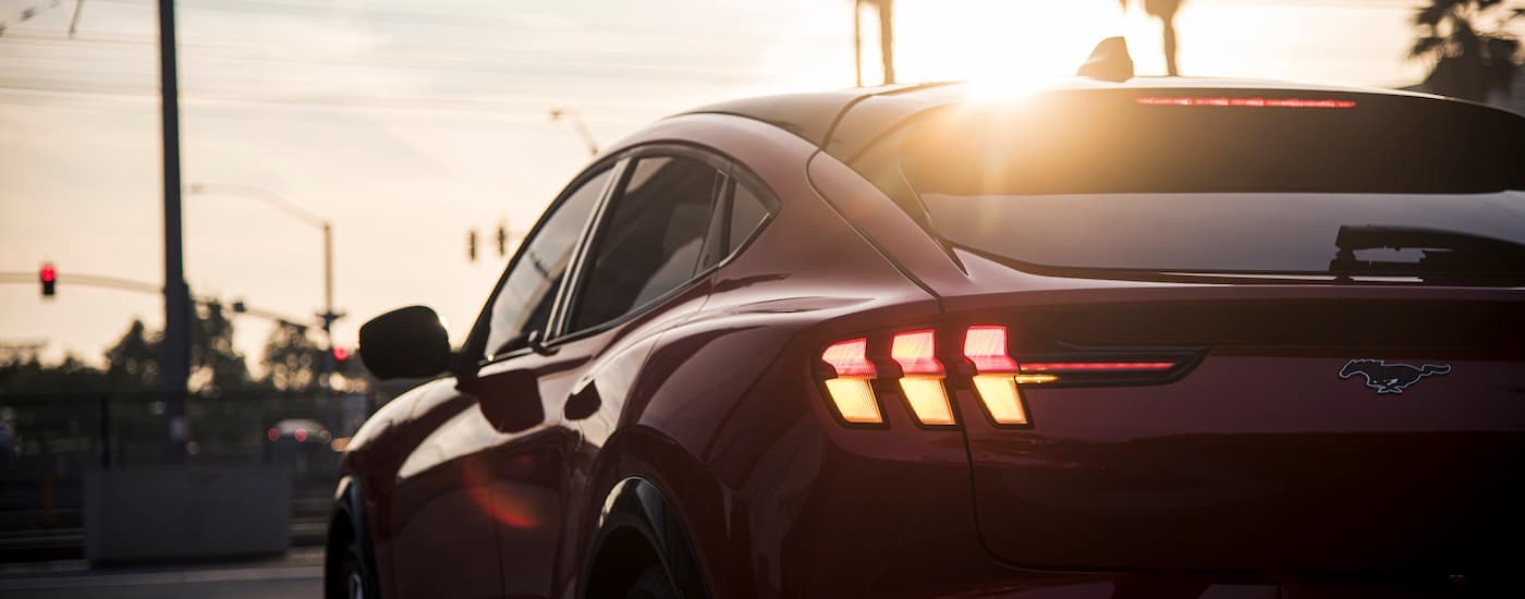 A red 2024 Ford Mustang Mach-E for sale is shown from the rear in close-up.