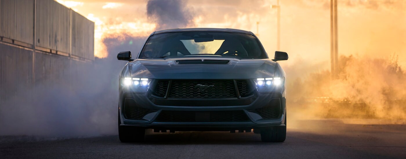 A blue 2024 Ford Mustang GT is shown from the front after leaving a Ford dealership.