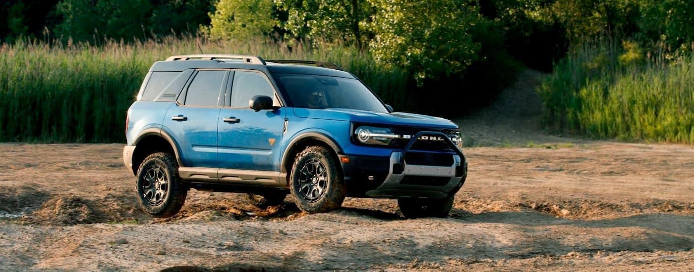 A blue 2025 Ford Bronco Sport Badlands is shown from the side while off-road.
