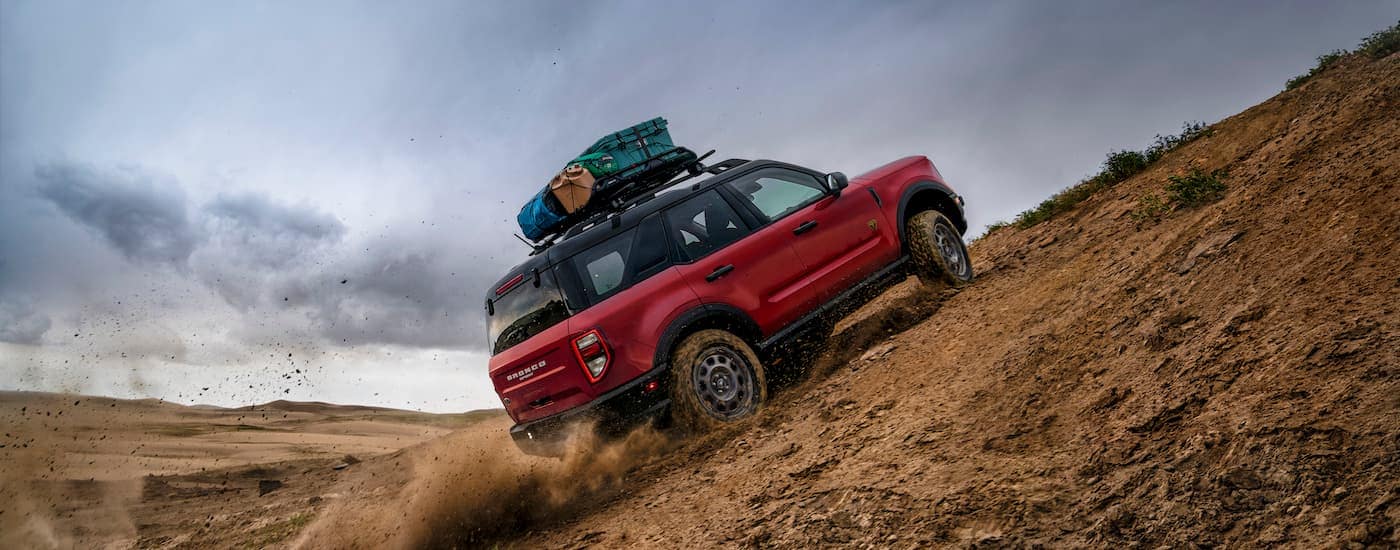 A red 2023 Ford Bronco Sport for sale in Milan is driving off-road.