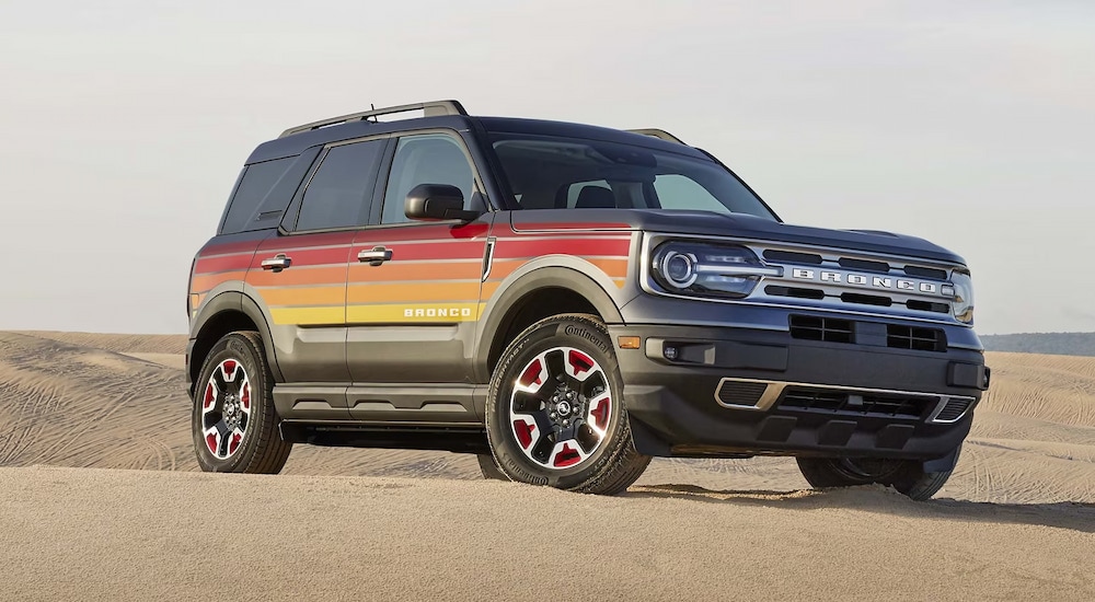 A multi-colored 2024 Ford Bronco Sport Free Wheeling parked on sand.