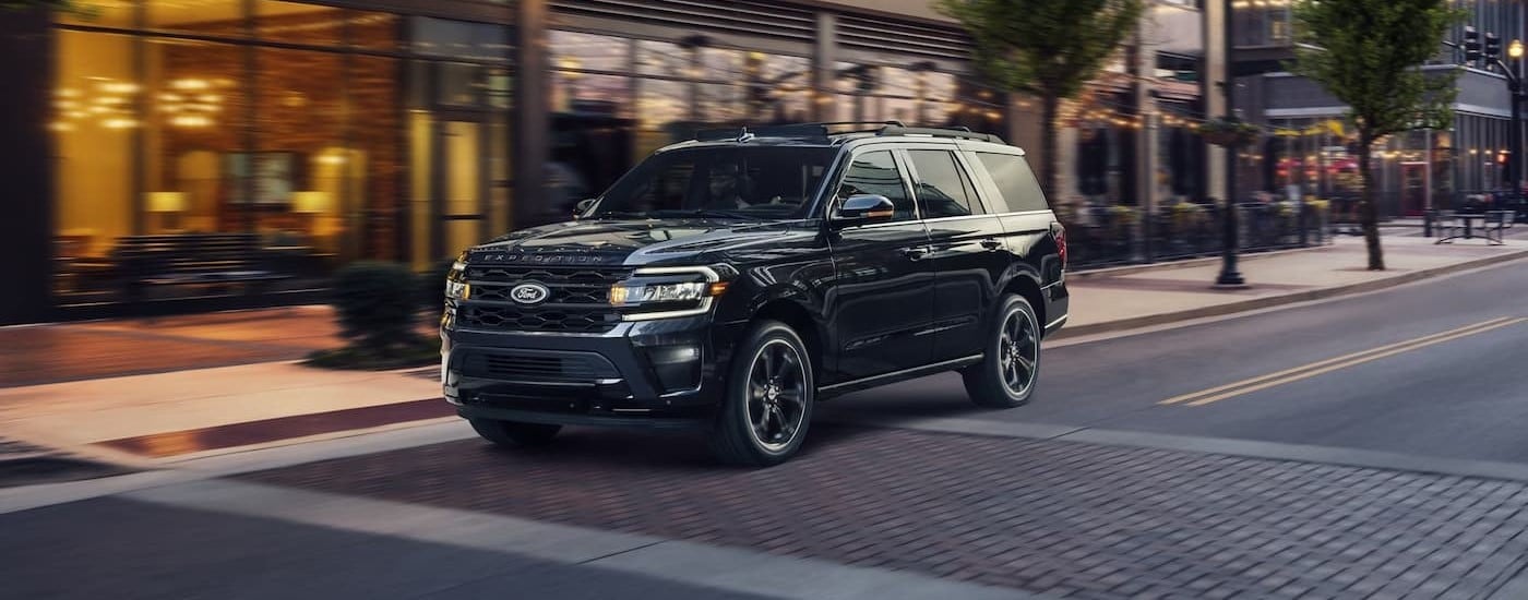 A black 2024 Ford Expedition is shown driving on a city street after visiting a Ford dealer near Union City.