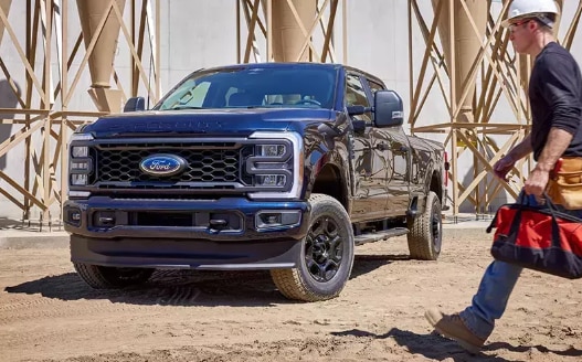 2025 Ford F-150® Raptor R® pickup in Carbonized Gray kicking up a cloud of dust in the desert