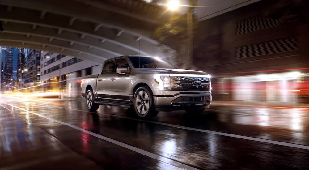 A silver 2024 Ford F-150 Lightning for sale is shown from the front at an angle.