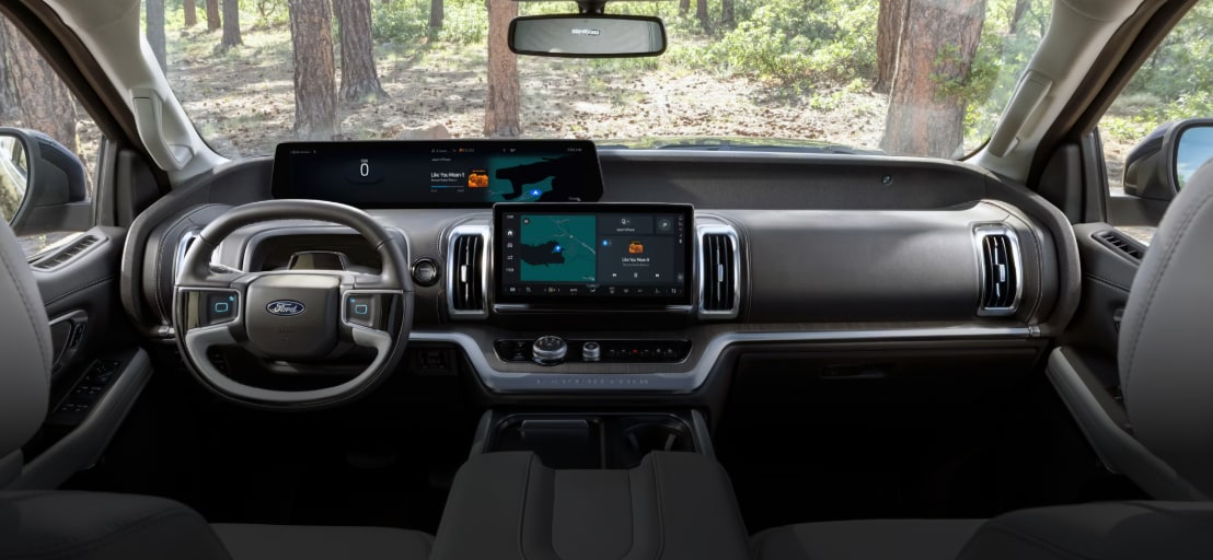 2025 Ford F-150® Raptor R® pickup in Carbonized Gray kicking up a cloud of dust in the desert