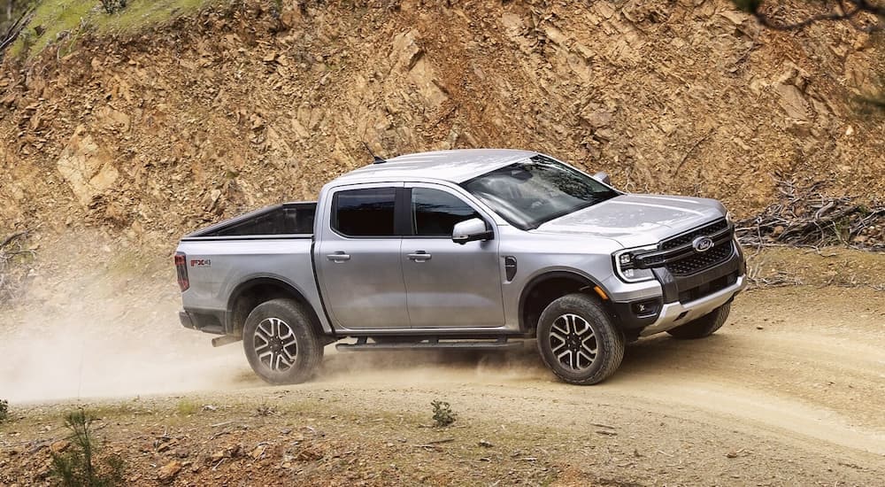 A grey 2024 Ford Ranger FX4 is driving on a dirt road after leaving a Ford dealer near McKenzie.