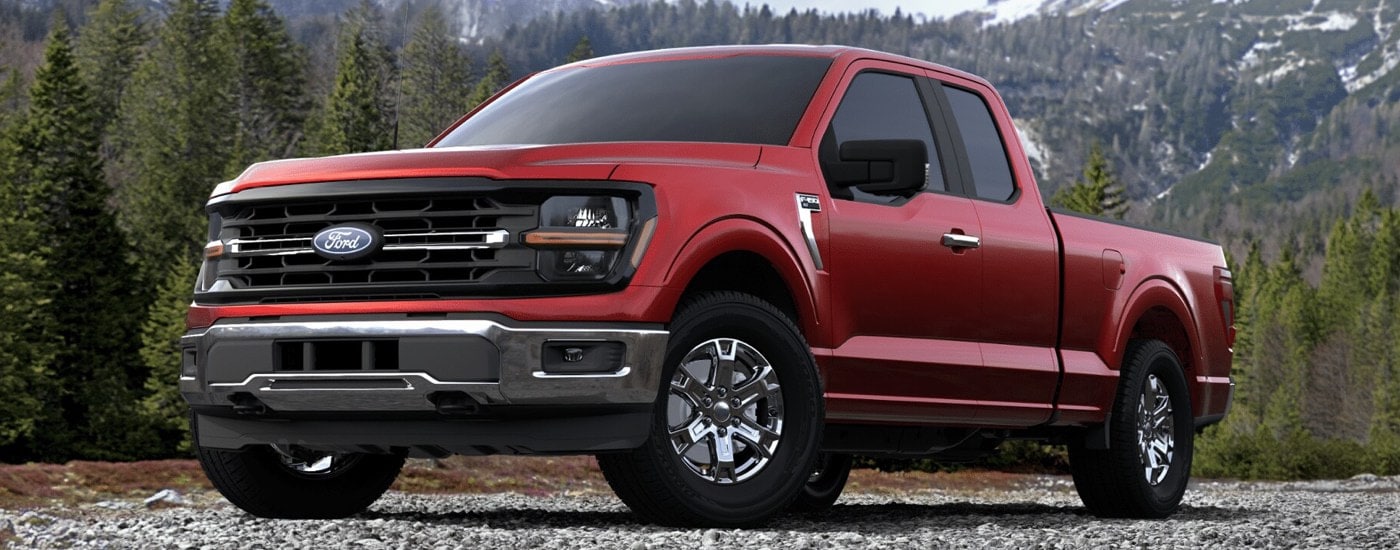 A red 2025 Ford F-150 XLT parked off-road in the mountains.