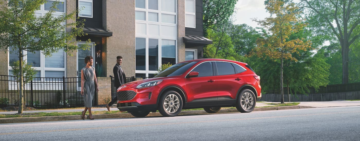 A red 2022 Ford Escape is shown from the side on a city street.